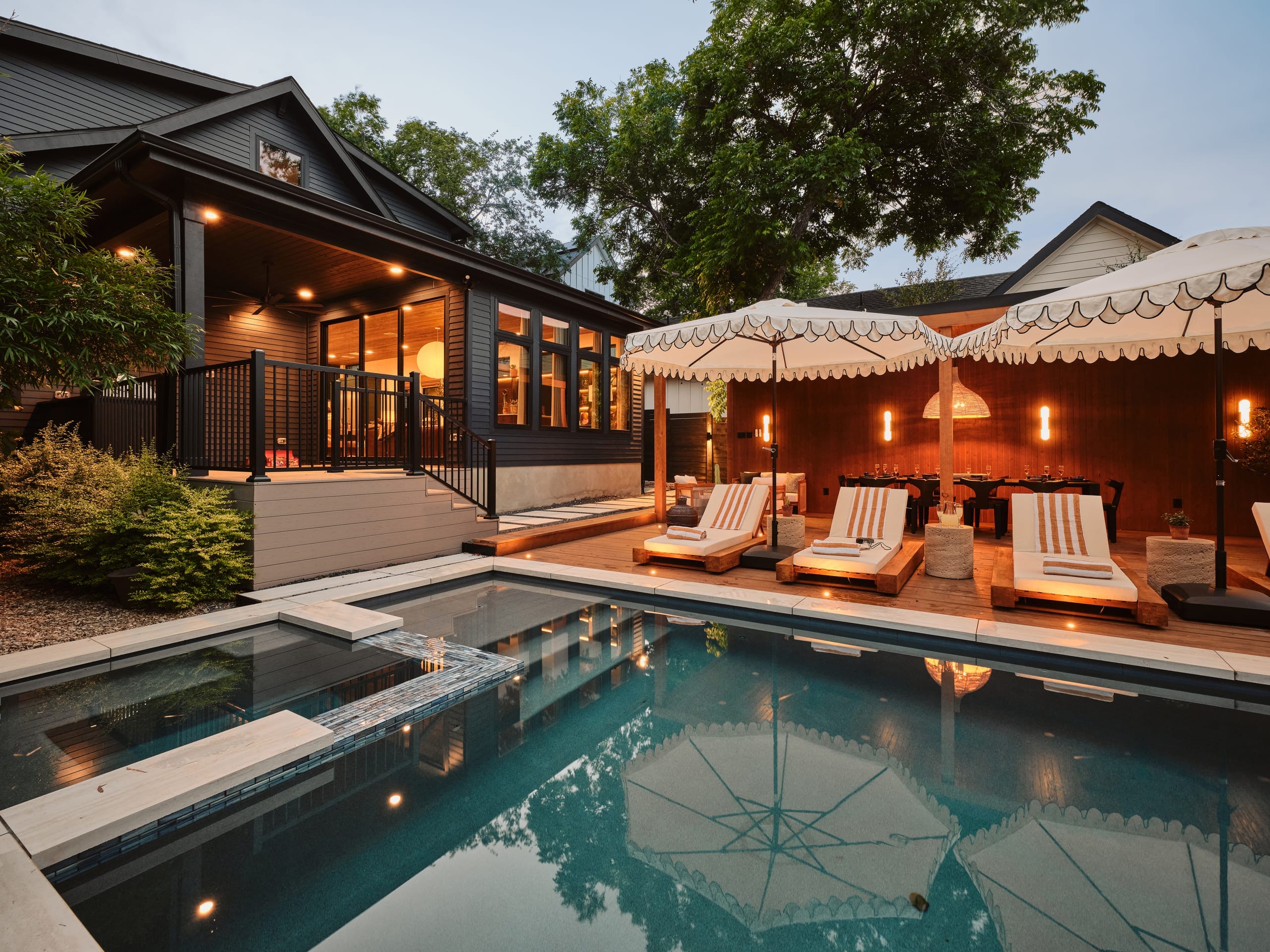 The pool at SoundHaus at golden hour, sun loungers along the deck with the house behind